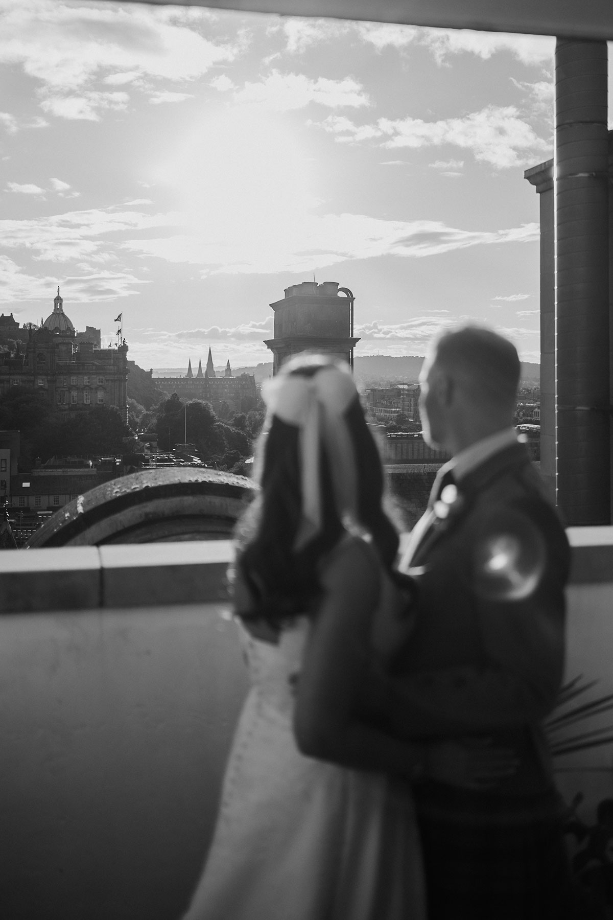 a bride and groom looking out over Edinburgh