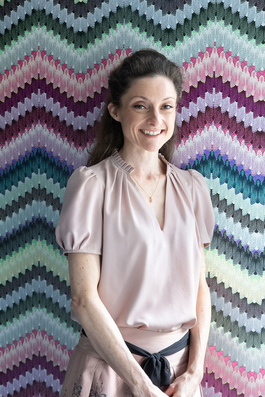 Rachel Snedden from Rachel Scott Couture posing against a colourful wall