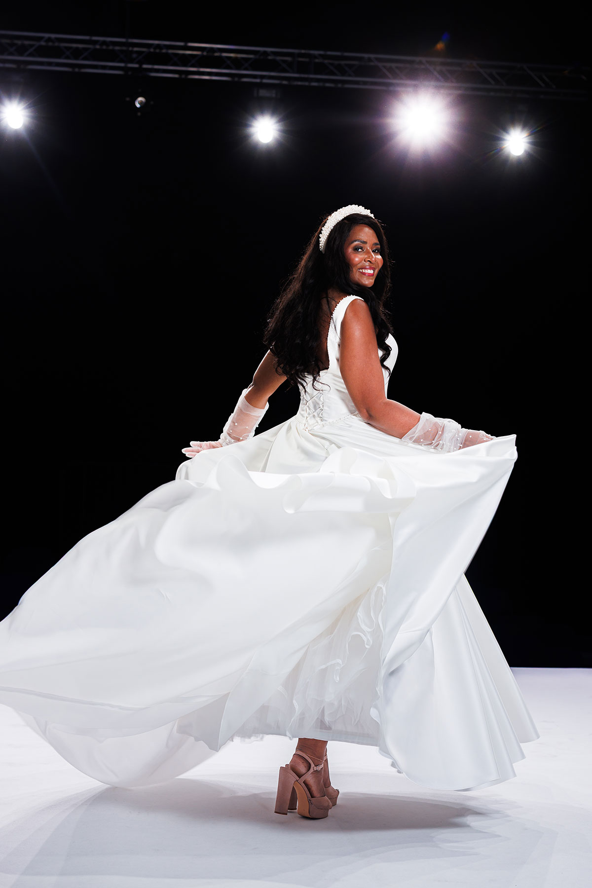 Bride twirling in a flowing wedding dress on the Scottish Wedding Show catwalk