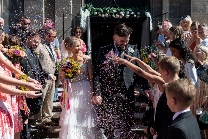 Confetti thrown at happy couple as they walk out their venue