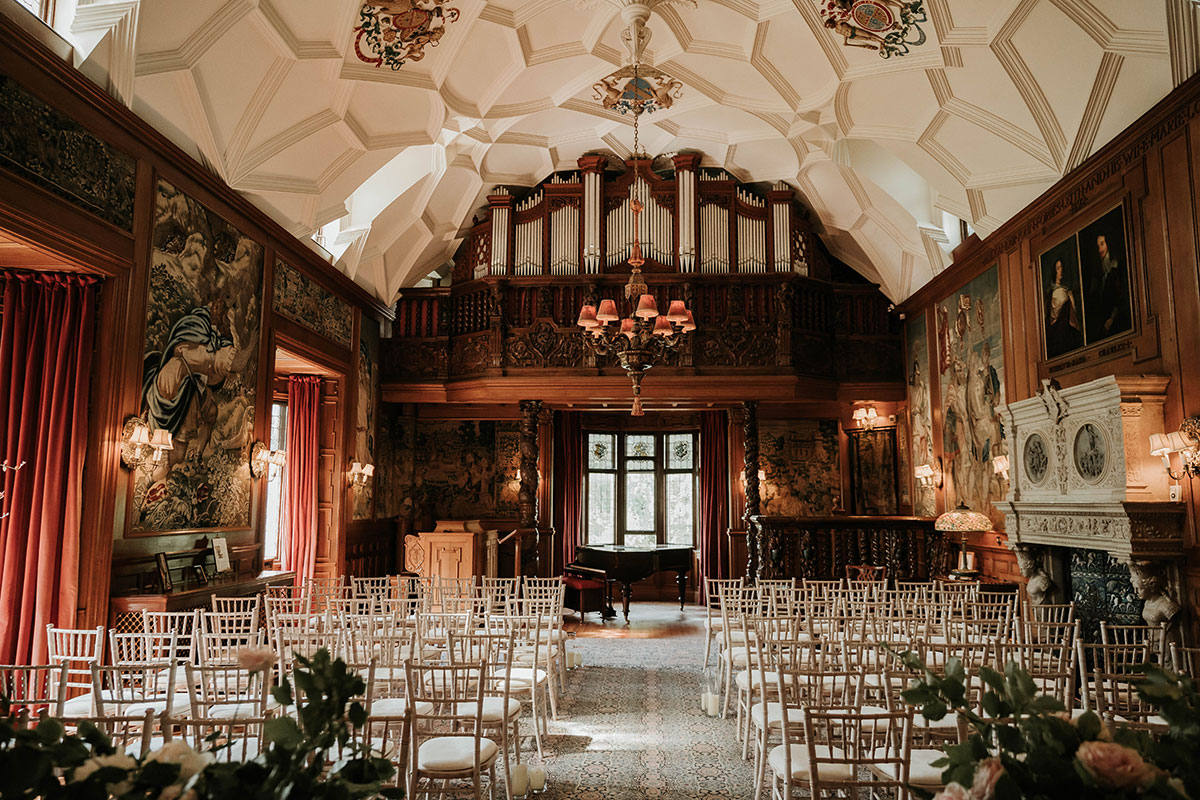 Music Gallery at Fyvie Castle set up for a wedding ceremony with Chiavari chairs, tapestries, grand piano and pipe organ