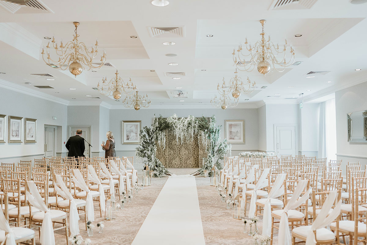 Ceremony room at Norton House Hotel set with gold chairs and floral arch for Scottish wedding
