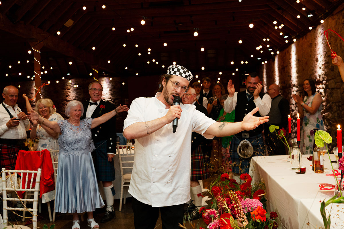 Surprise singing waiter from Singers Secreto with guests cheering in background.