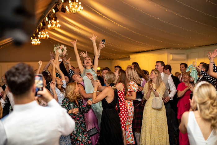 Guests jumping to catch the bride's bouquet