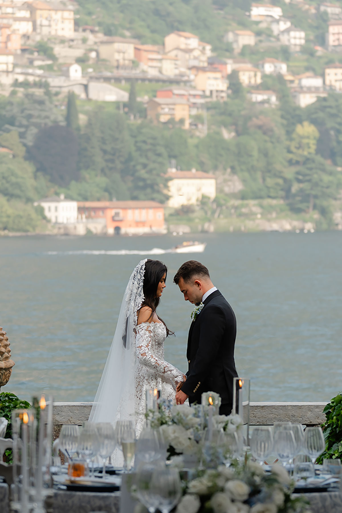 Bride and groom posing on the terrace at Villa Regina Teodolinda with panoramic views across Lake Como.