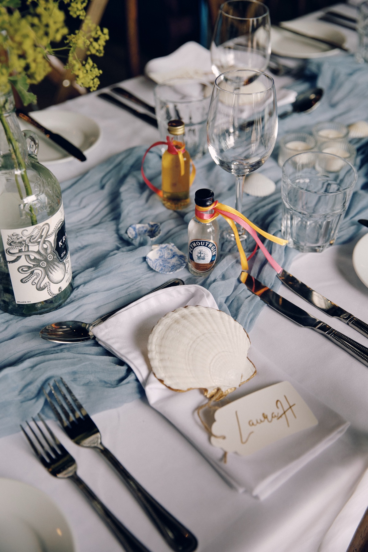 Nautical wedding table styling with a shell place setting, blue runner and mini gin and whisky favours at The Dougarie Boathouse.