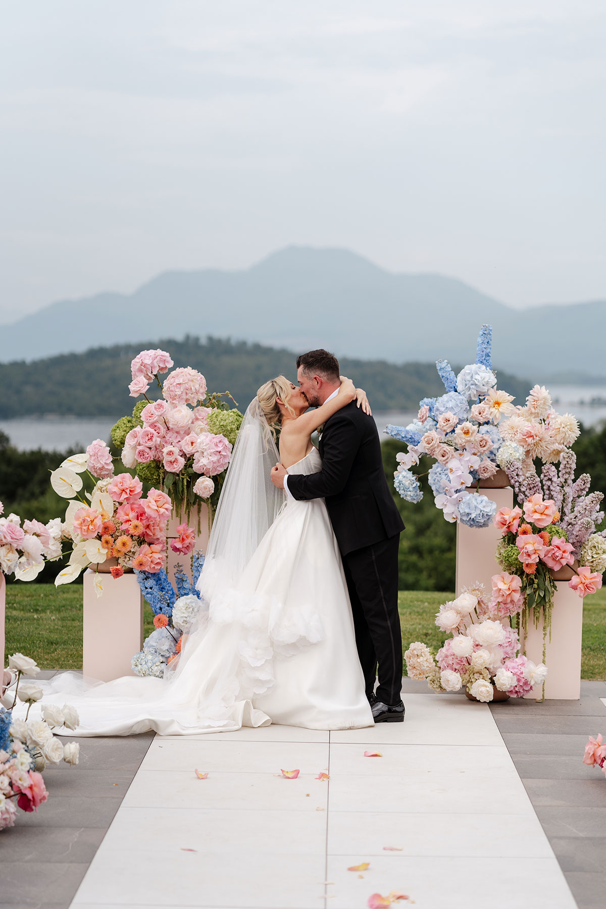 Newlyweds share their first kiss during an outdoor ceremony at Boturich Castle with Loch Lomond behind them.