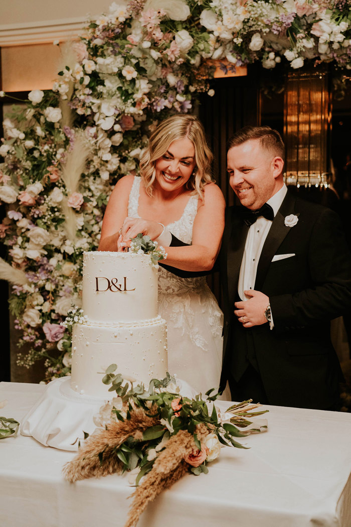 A bride and groom cutting a wedding cake.