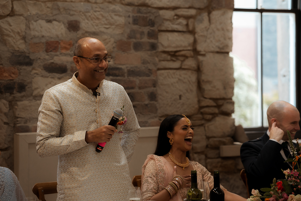 A Man Wearing An Ivory Salwar Kameez Standing Holding A Microphone At The Haberdashery In Glasgow