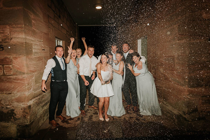 a group of people doing a champagne spray at Dunglass Estate wedding