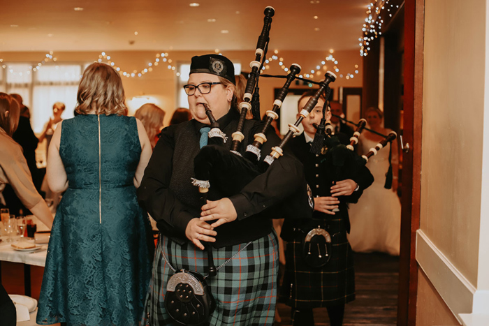 Pipers play as couple walk into their wedding breakfast