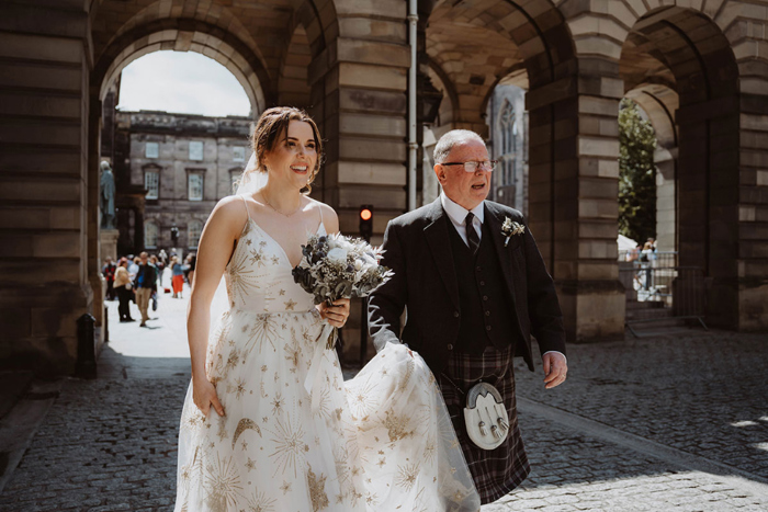 Bride and father walking through Edinburgh