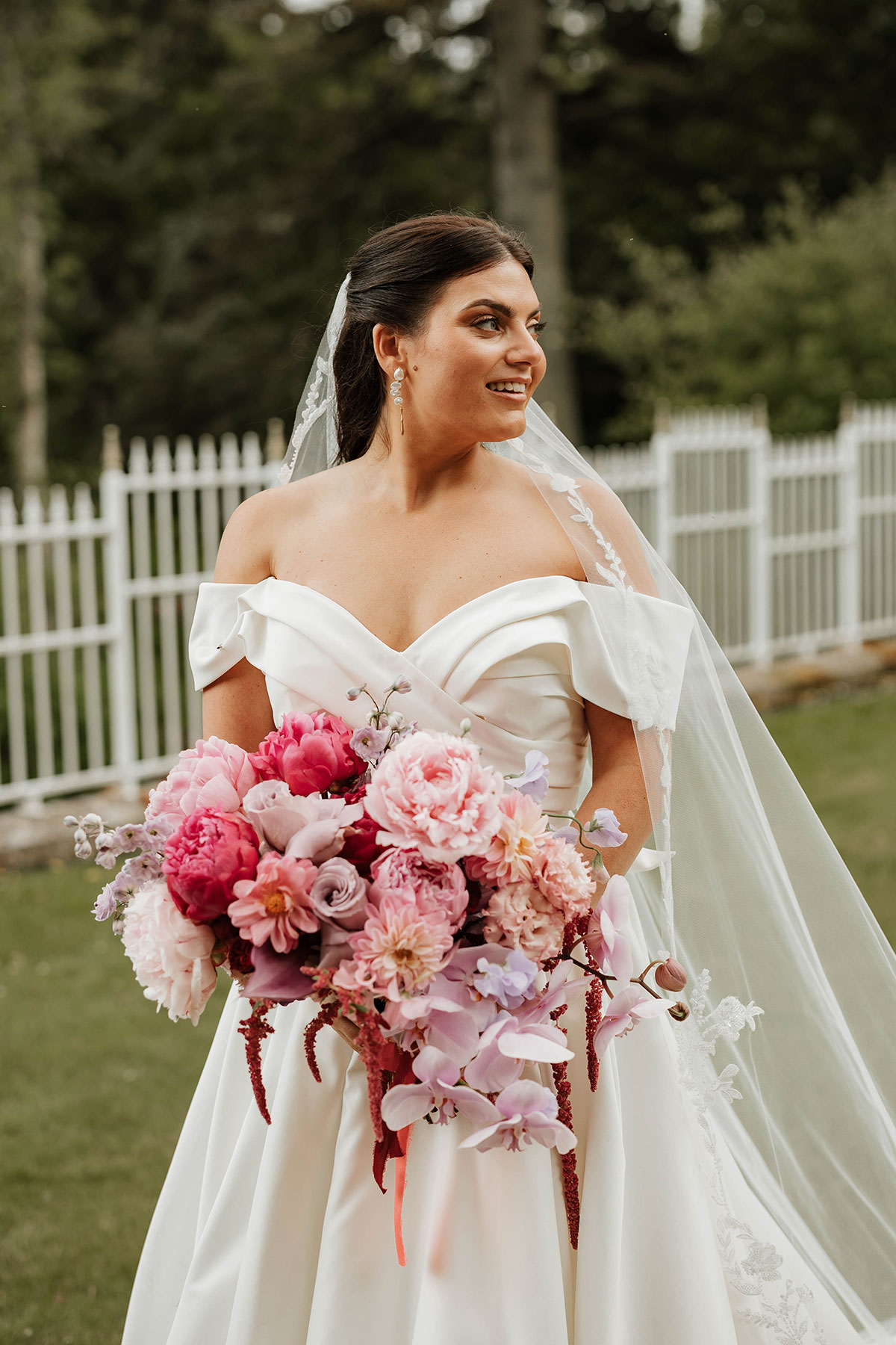 Bride holding pink and red bouquet by Kim Dalglish Florist at Drumtochty Castle Aberdeenshire wedding