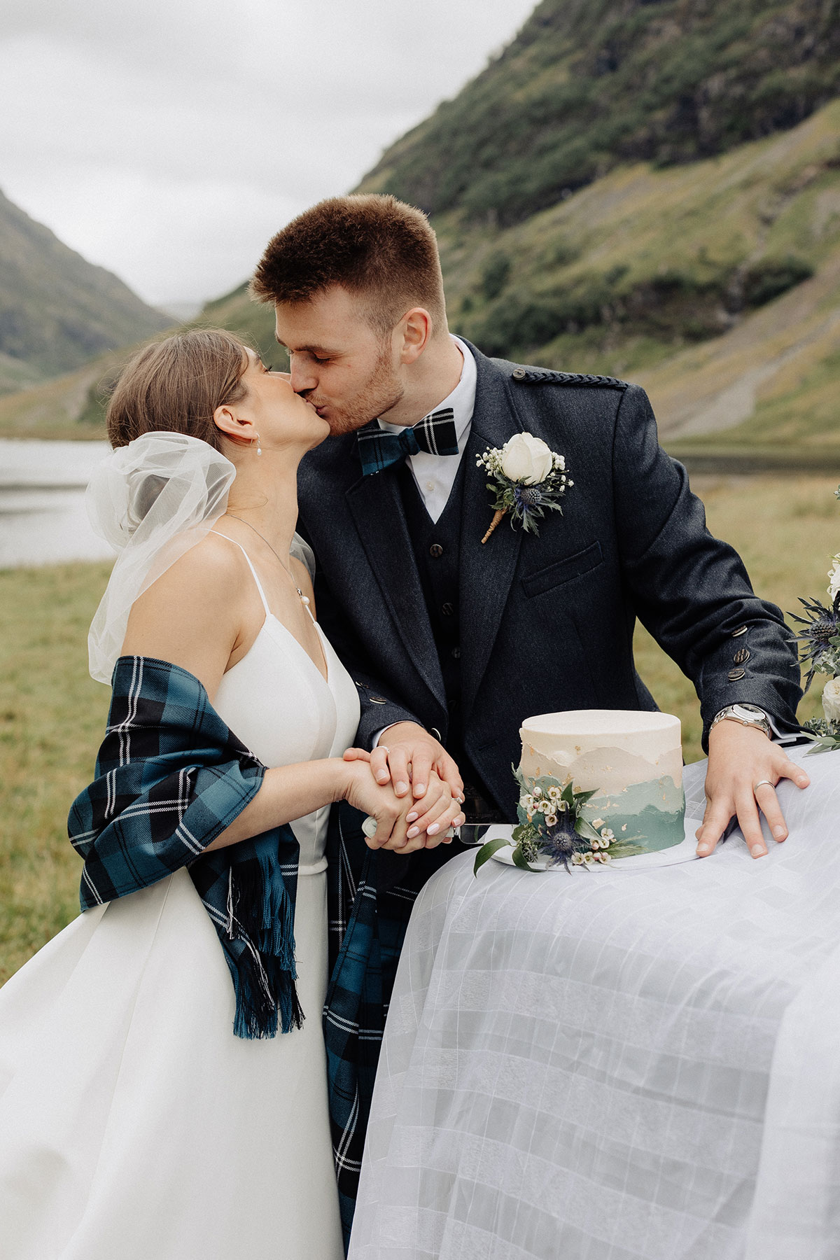 bride and groom kiss while cutting wedding cake in glencoe