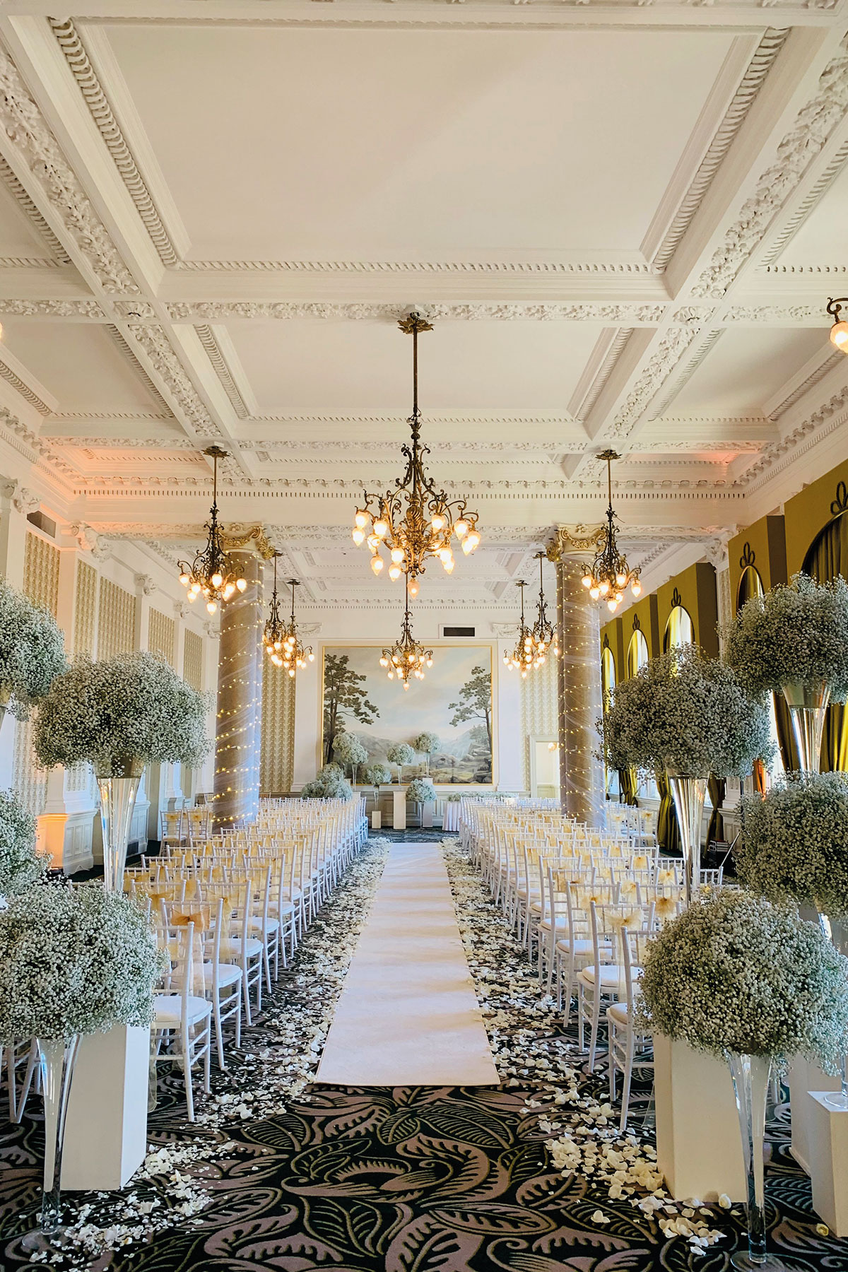 Wedding ceremony setup in the Sir Walter Scott Suite at The Balmoral Edinburgh with grand columns, floral aisle and luxury décor