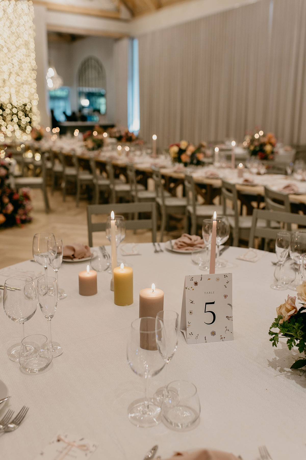 Romantic wedding table styling with candles, floral table number and elegant reception décor at Boschendal Wine Estate