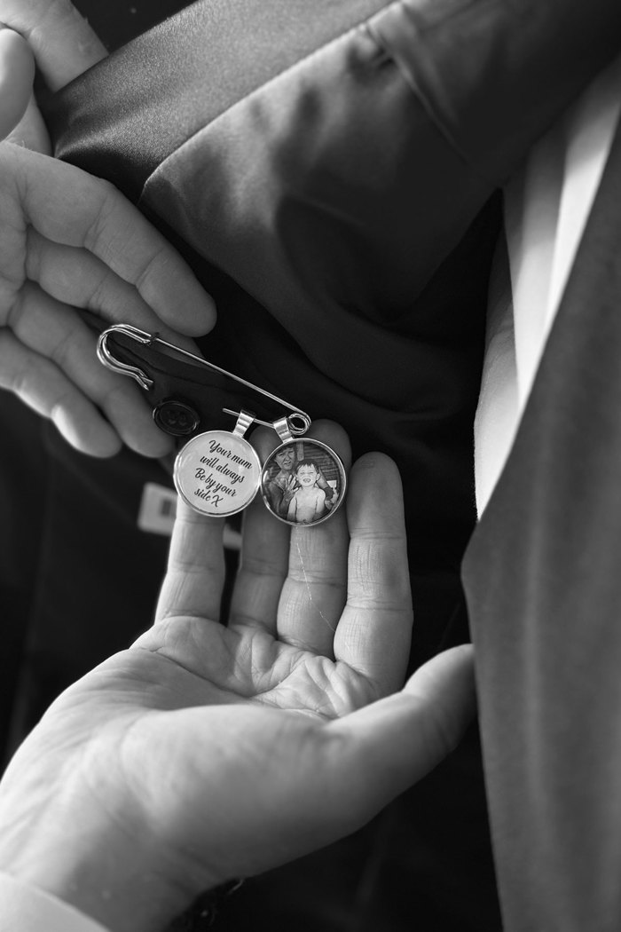 black and white picture of a hand holding a brooch that has a picture on it