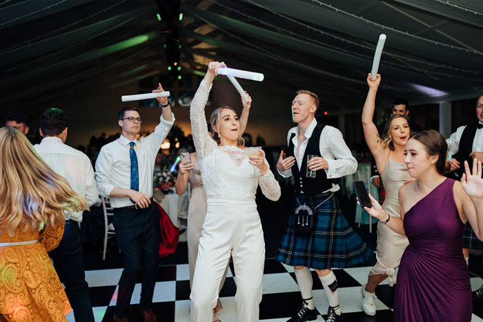 A group of people dancing and holding up baton.