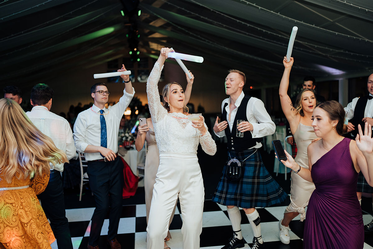 A group of people dancing and holding up baton.