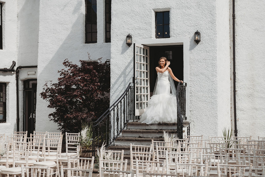 Bride emerges from doorway in a white gown before first look