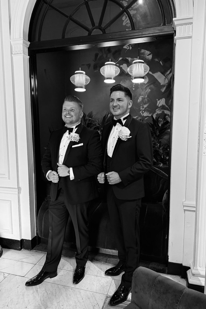 black and white picture of two grooms wearing gilt edge tuxedos