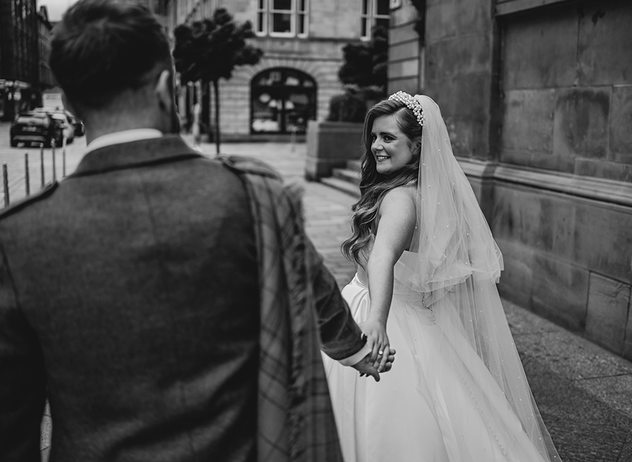  Black And White Image Of Bride Looking Back At Groom