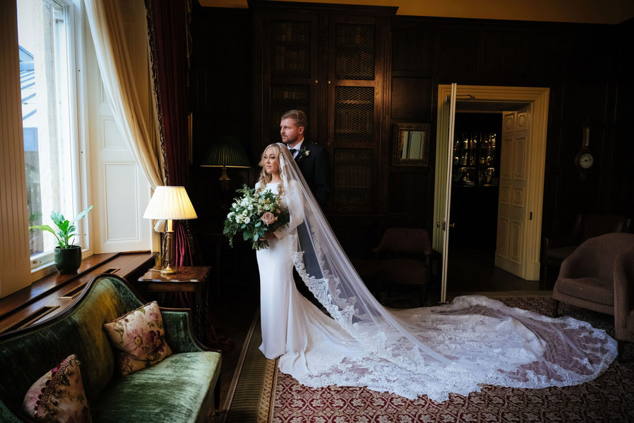 bride and groom look out the window inside crossbasket castle