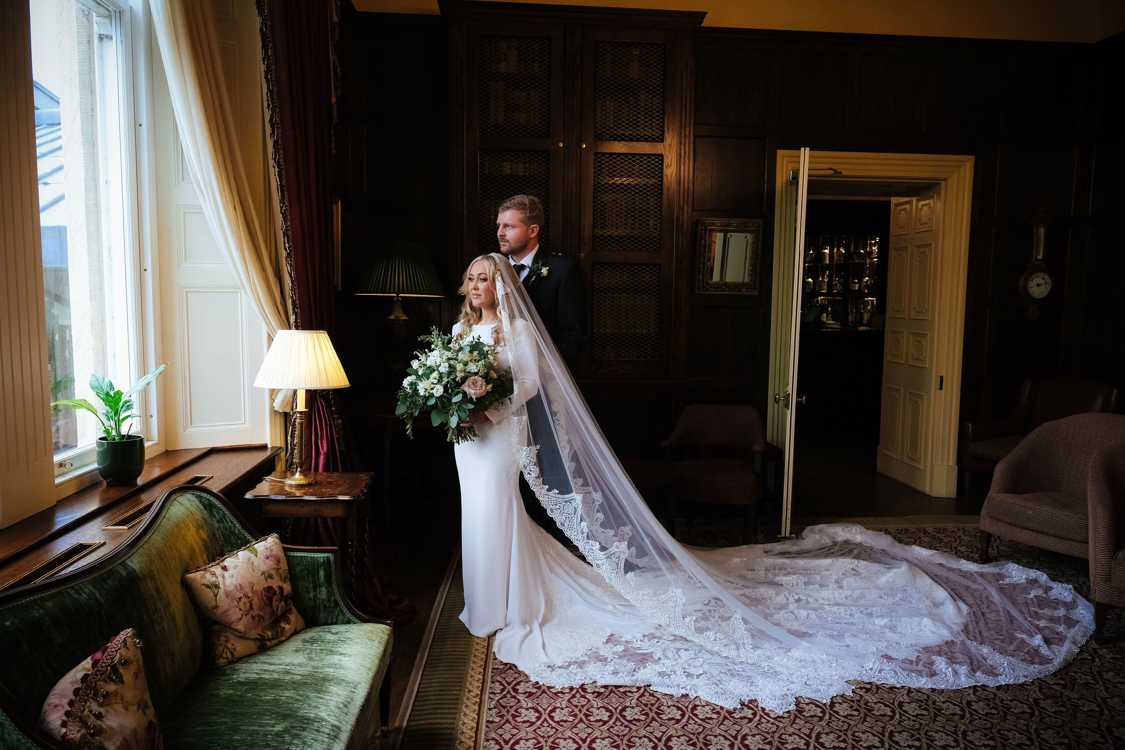 bride and groom look out the window inside crossbasket castle