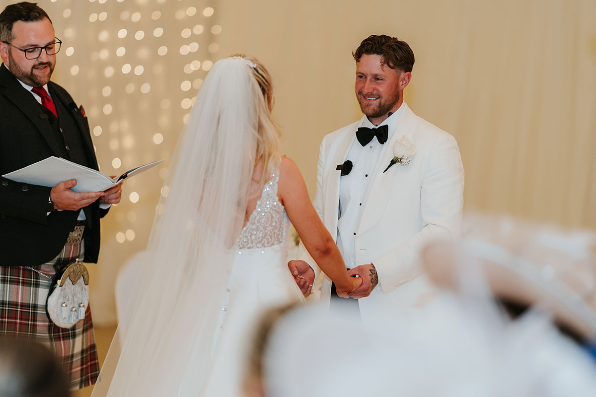 Groom smiling during wedding ceremony at Ingliston Country Club