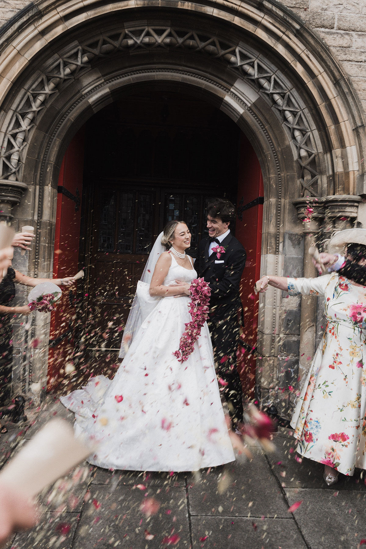 Bride and groom under colourful confetti shower outside Mansfield Traquair ceremony