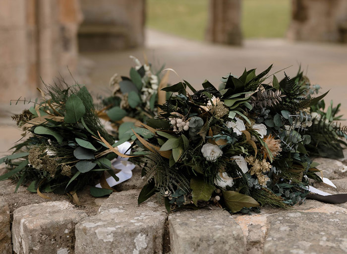 foliage bouquets sitting on an old stone wall