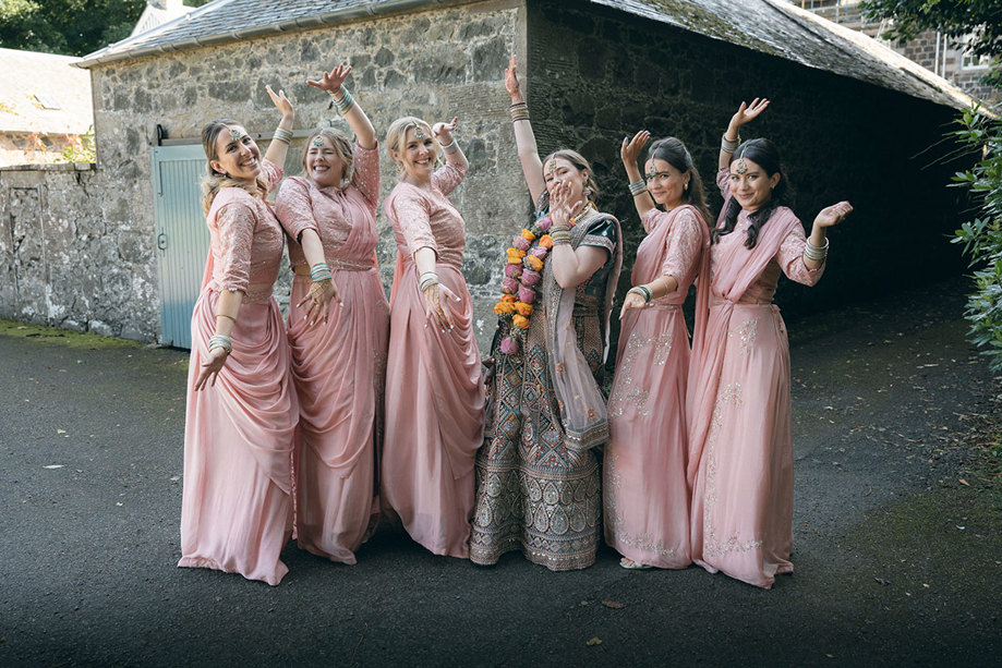 A group of women in pink dresses posing for a photo.