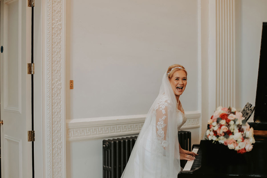 Bride laughs as she plays the piano