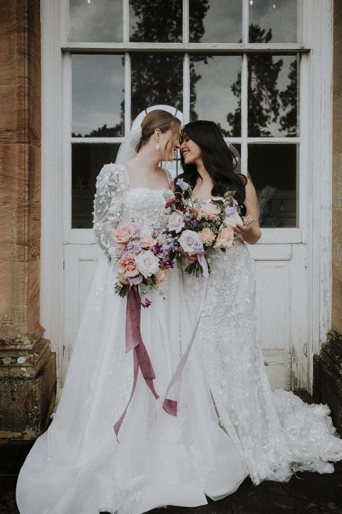 brides gazing at one another holding flowers Chatelherault shoot