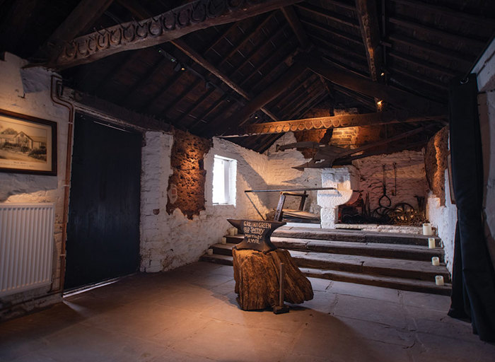 Interior of the Old Blacksmiths Shop at Gretna Green with marriage anvil on a wooden trunk