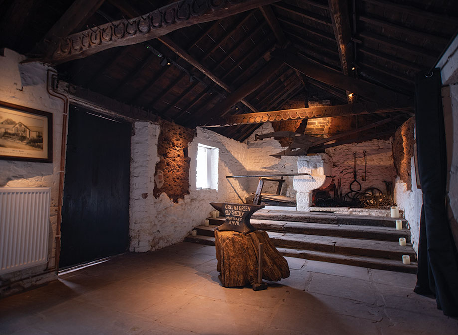 Interior of the Old Blacksmiths Shop at Gretna Green with marriage anvil on a wooden trunk