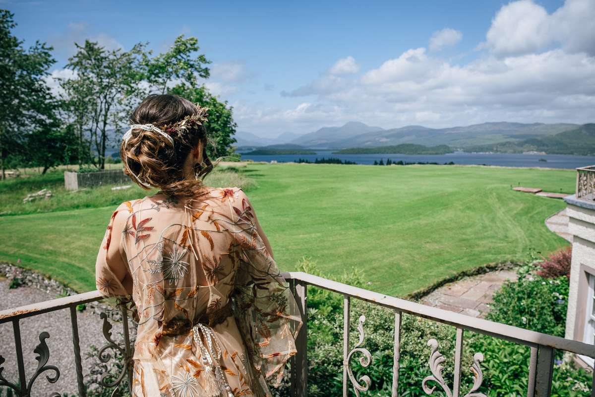 Bride looking out over Loch Lomond and the surrounding mountains from Ardoch Loch Lomond