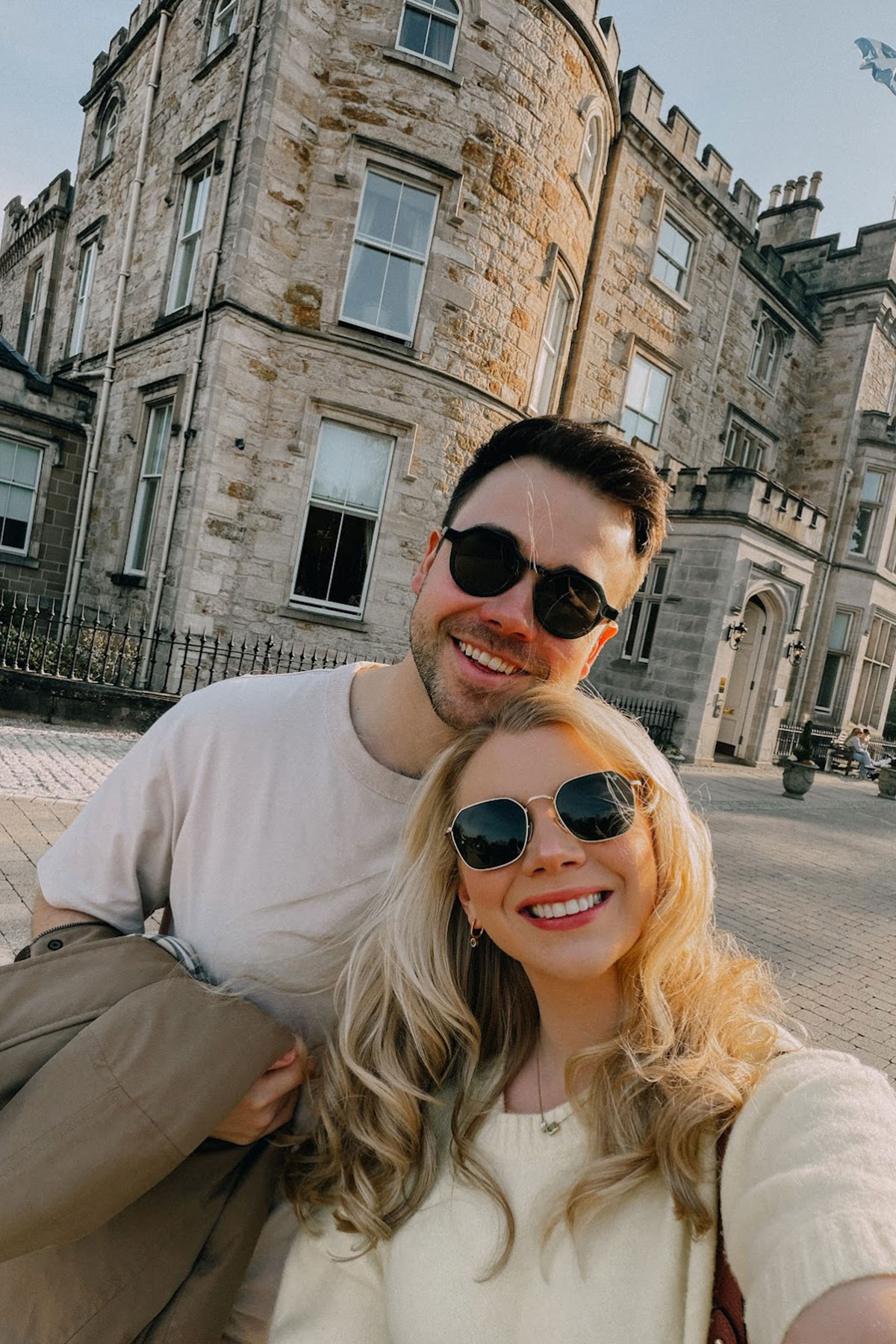Couple taking a selfie outside a Scottish castle hotel during an engagement weekend getaway