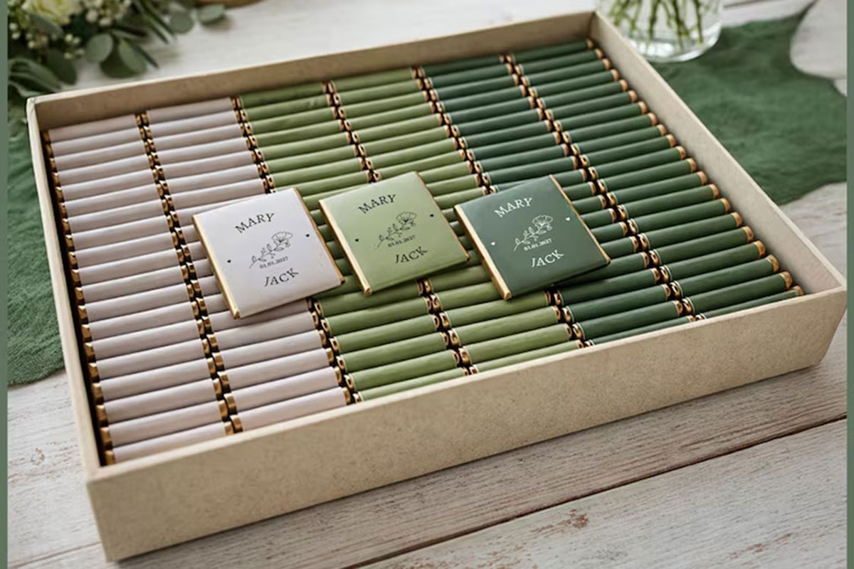 Personalised chocolate bar wedding favours displayed in green and neutral packaging