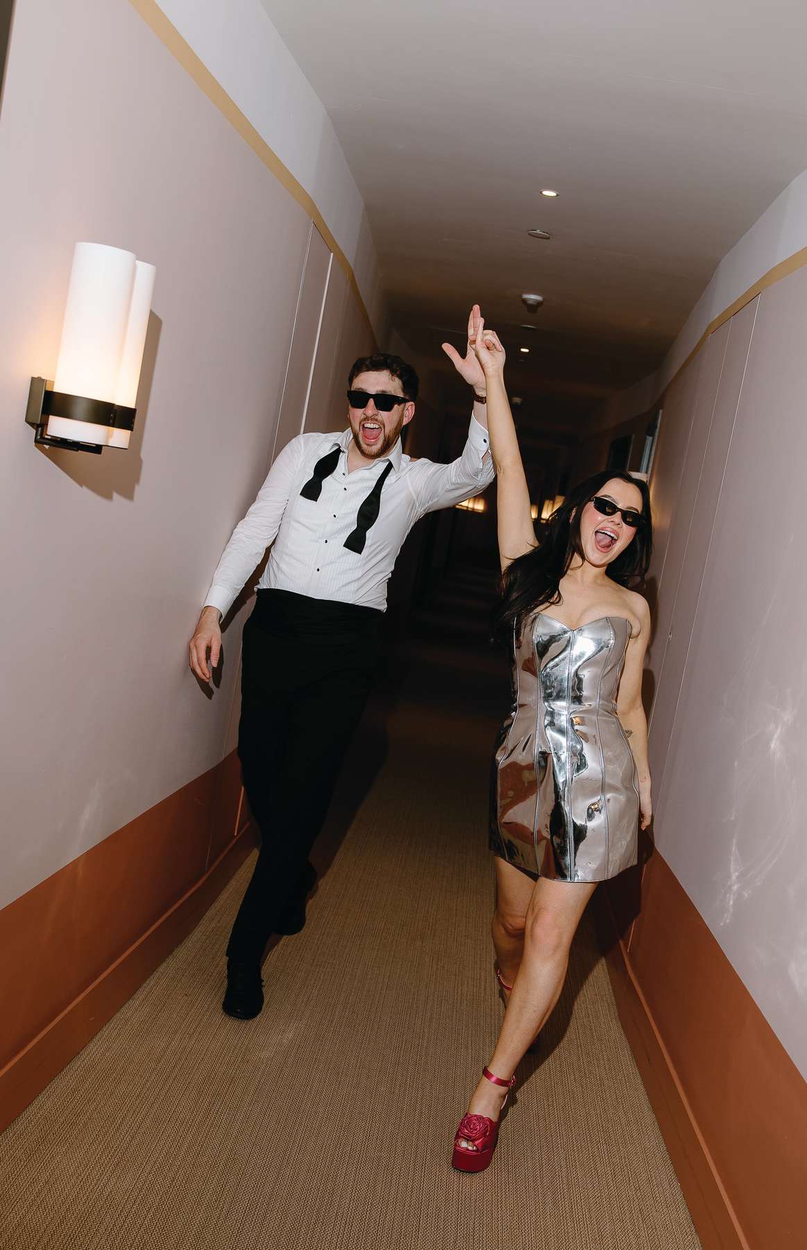 Bride in a chrome mini dress and groom in black tie celebrate during their wedding after-party at The Hoxton Barcelona.