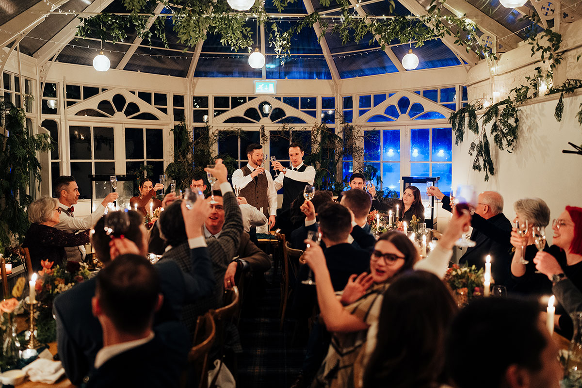The newlyweds raise a toast with guests during their candlelit wedding reception