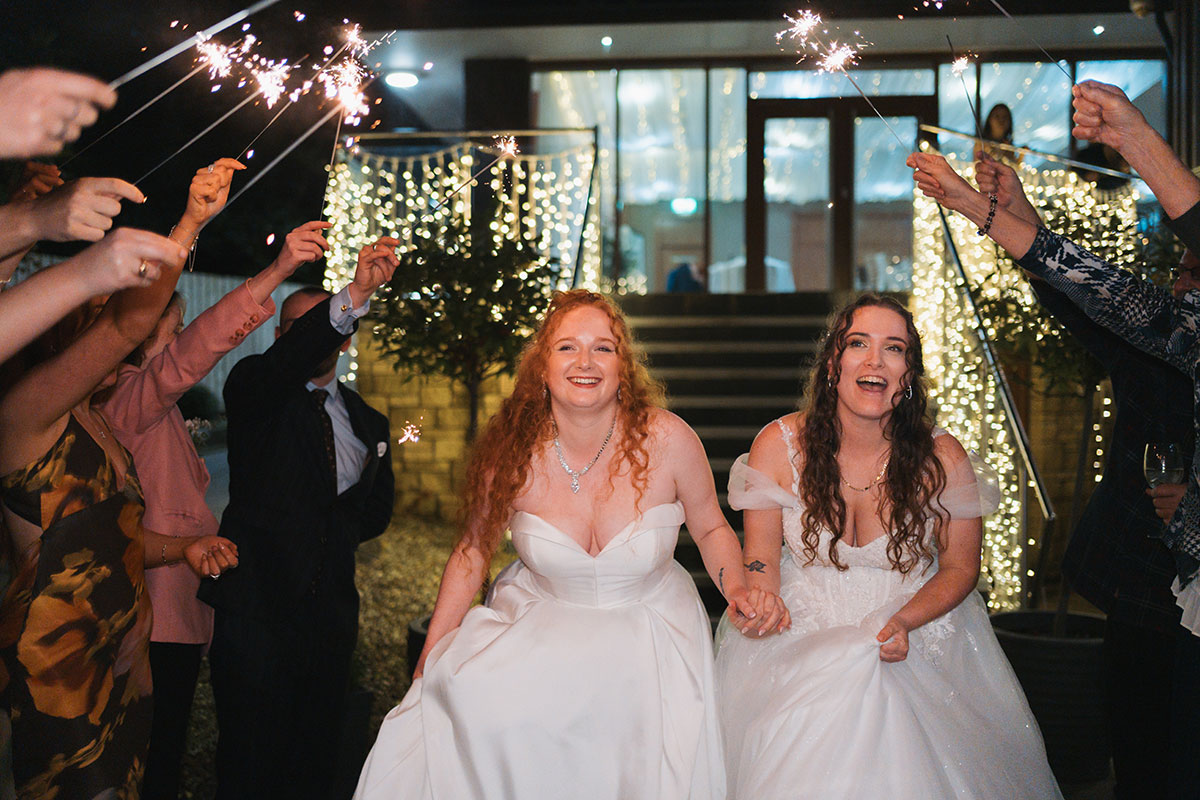Brides walking through sparkler exit at Lodge on Loch Lomond evening wedding celebration