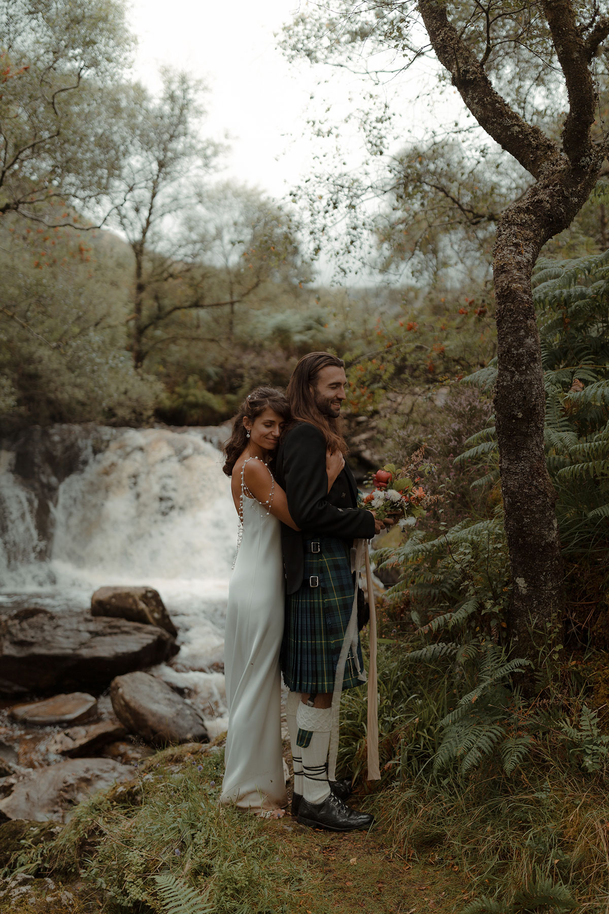 bride and groom by waterfall at Carrick Castle Estate