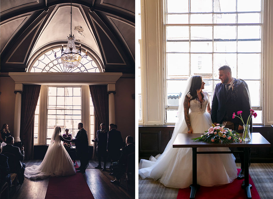 A bride and groom during their ceremony standing in front of a large window