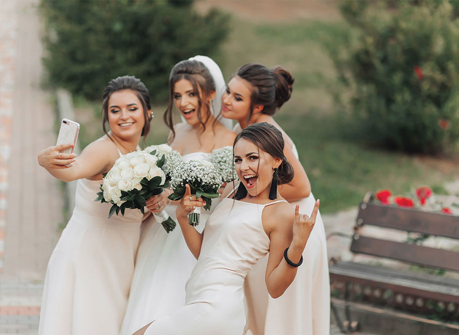 A bride and bridesmaids pose for a selfie