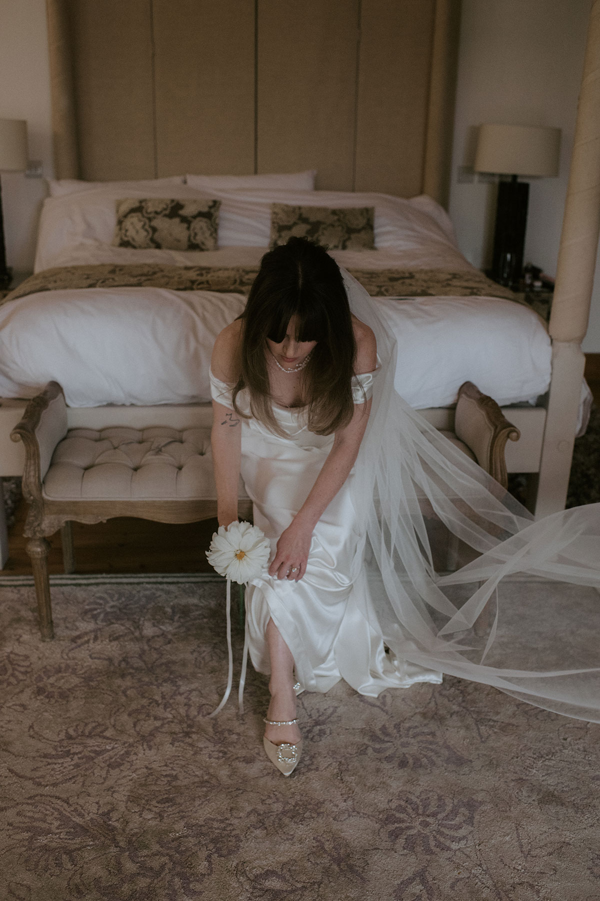 a bride seated on a chair in a bedroom at Achnagairn Castle
