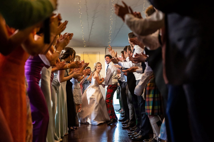Guests clap as bride and groom ceilidh dance