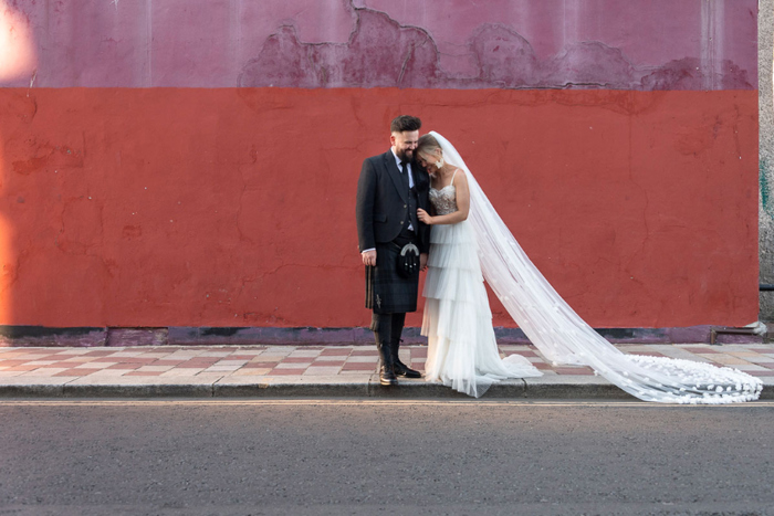 Cat Markie Photography captures couple portrait against red wall