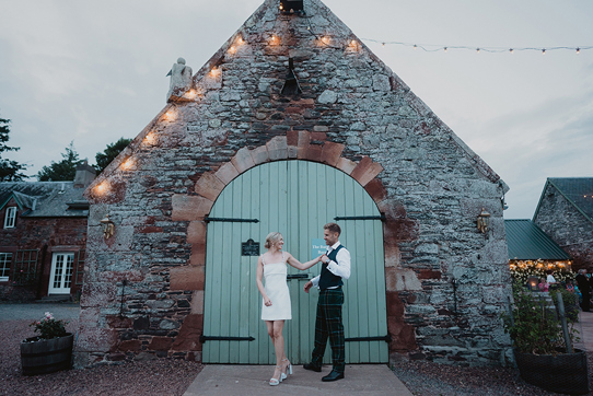 A Bride And Groom Pose By A Green Barn Door At Wedderlie House