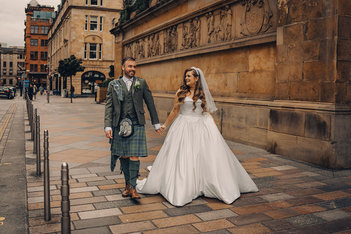 a bride and groom walking hand in hand outside Citation Glasgow wedding venue